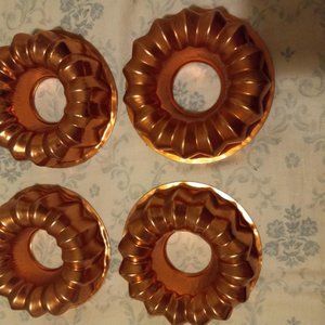 4 small copper molds. All are the same design. Can be hung on wall.